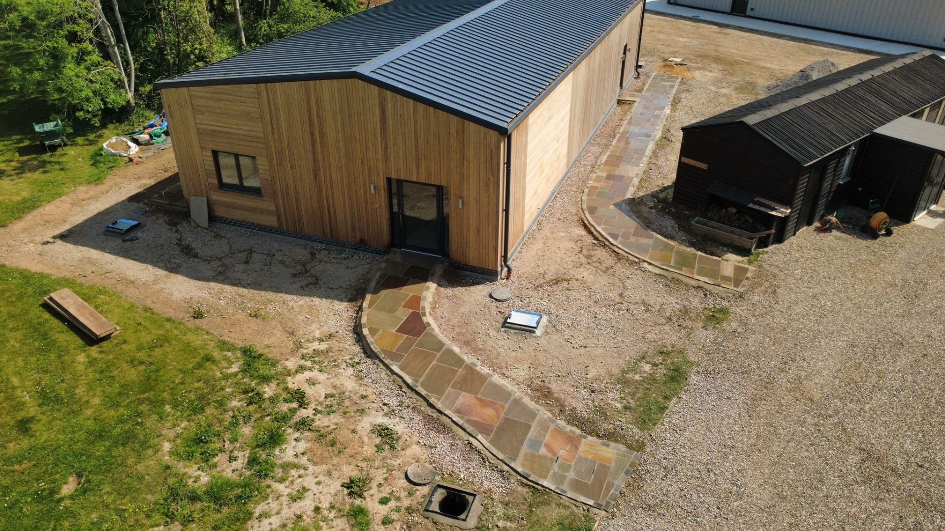 Aerial view of bespoke Indian sandstone pathway around timber-clad building
